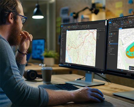 worker sitting at ArcGIS Pro screens